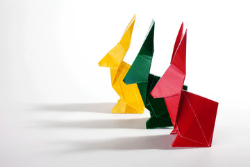 Naklejka premium Colored origami rabbits over a white background