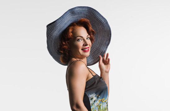 Portrait Of A Mature Woman With Red Hair And A Hat.