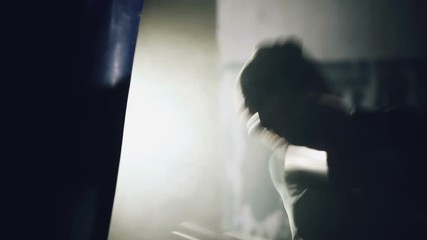 Young Boxer fighter over black background in the underground sport club