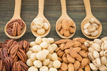 Group of nuts on wooden table. Almonds, pistachios, macadamia and pecan nut