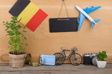 blank blackboard, flag of the Belgium, airplane model, little bicycle and suitcase, camera, compass