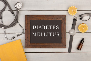 Blackboard with text "Diabetes Mellitus", stethoscope and book