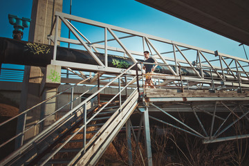 Naklejka premium young man running over metal bridge