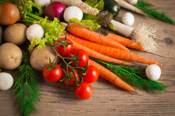 Fresh vegetables on a wooden table. Carrot, parsley root, zucchini, beet ,onion, leek and tomatoes.