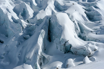 Fototapeta na wymiar Detail of glacier flow and crevasses covered by snow in winter