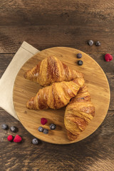 Crunchy French croissants with fresh raspberries and blueberries