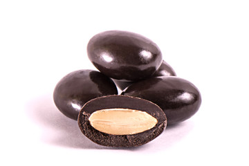 group of nuts in chocolate on a white background. Part cut in half.