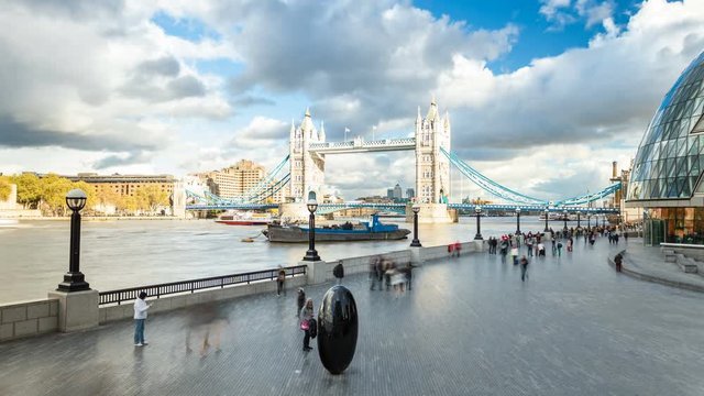 Timelapse of Tower Bridge, black egg shaped sculpture on the South Bank and City Hall, The Scoop against cumulus clouds in a blue sky, London, UK