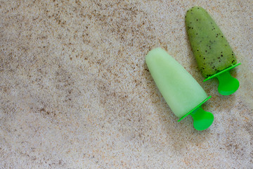 Ice cream with kiwi and fruit ice on a stone background, copy space. The concept of a healthy diet...