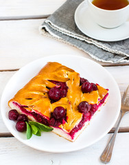 Cherry pie on white plate. Wooden background.