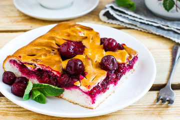 Cherry pie on white plate. Wooden background.