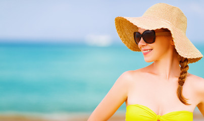 woman in sunglasses,  hat and  bikini on beach.