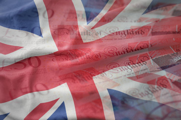 colorful waving national flag of great britain on a pounds money banknotes background. finance concept © luzitanija