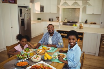 Portrait of family having meal on dinning table at home