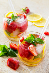 A refreshing summer drink with ice and strawberries on a stone background. The concept of eating vegetarians, fresh vitamins, a homemade refreshing fruit drink.