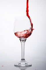 Pour a glass of red wine is. On a white background