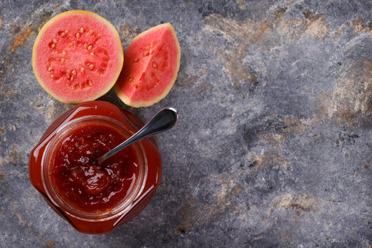 Brazilian dessert goiabada - jam of guava with fresh goiaba on gray background. Selective focus. Copy space