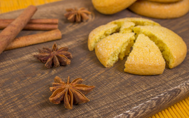 star anise on a board of wood with cookies and cinnamon