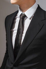 A man in a black suit and a white shirt