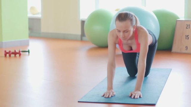 Girl doing warming up exercise for spine, backbend, arching stretching her back working out at home or yoga class.