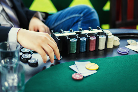 Poker chips on table with hands and cards in casino,Casino poker chips,men playing poker,poker game concept