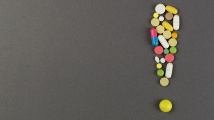 Exclamation point created from colored pills. Medical concept