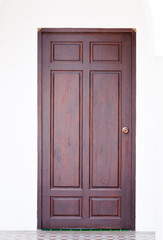 frame and panel wooden door on white wall background,Frontal image of a closed wood door