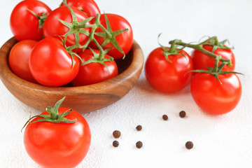 Fresh tomato juicy on a branch close-up on a light background horizontal view top view