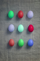 Pattern of Rows of colored easter eggs grey linen textured background. Easter web Background. Group of colored painted eggs. Happy Easter celebration concept. Template mock up with copy space for text