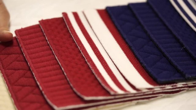 Female hands flips a fabric sample for curtains, upholstery upholstery, panels and car interior
