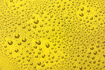 Drops of water on a color background. Yellow