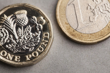 New British sterling on pound coin alongside old version