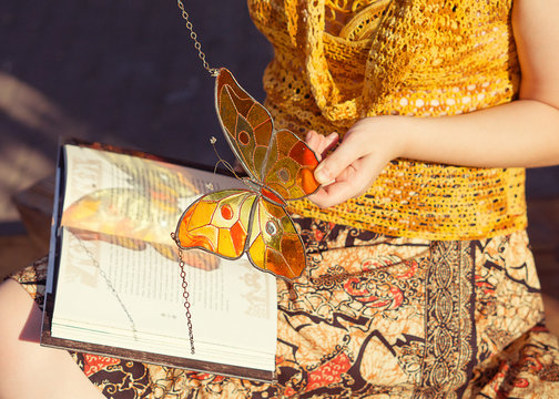 Handmade stained glass butterfly in woman's hands