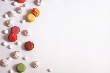 White background with meringue, macaroons and cranberries in sugar