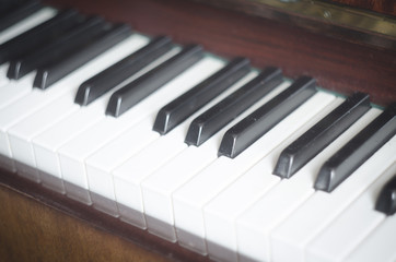 Naklejka premium Piano keyboard background with selective focus. Warm color toned image