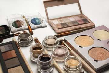 Flat lay of eyeshadow palettes,cosmetic brushes and pigments