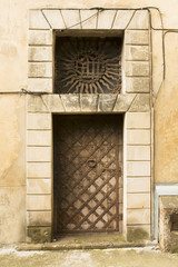 Fototapeta na wymiar Old wooden door with metal elements and rusty handle