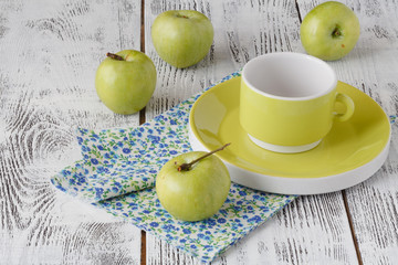 Fresh green apples in a dish on a rustic background.