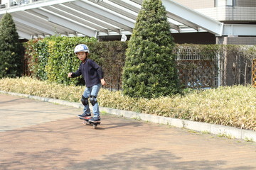 Obraz premium Japanese boy riding on a casterboard (first grade at elementary school)