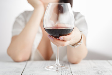 woman drinking alcohol on white background. Focus on wine glass