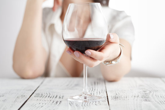 woman drinking alcohol on white background. Focus on wine glass