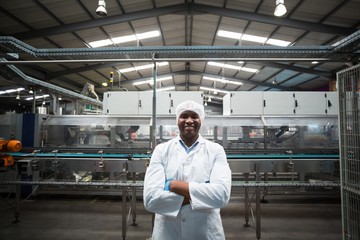 Portrait of factory engineer standing with his arms crossed