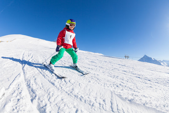 Little skier hitting the slope in alpine resort