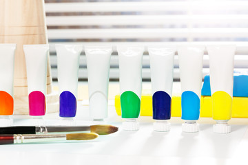 Small tubes of tempera standing in row on table
