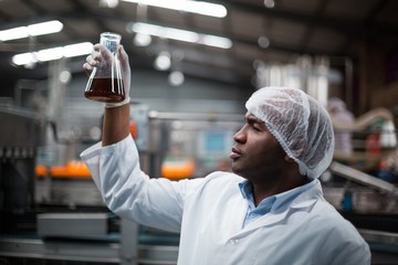 Factory engineers checking a sample of drink
