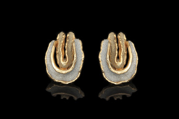 Gold earrings on a black background