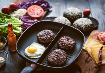 Ingredients for a black burger on a wooden surface