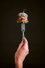 Black mini burger on the fork