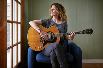a young woman playing a guitar