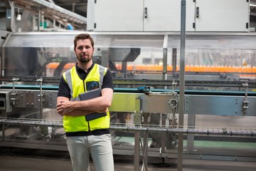 Portrait of factory worker standing with a tablet